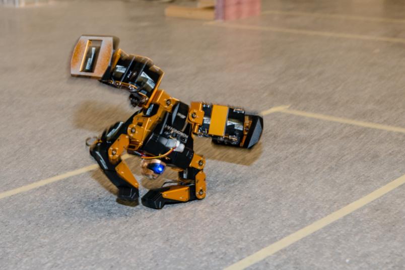 Ein kleiner gelber Roboter macht einen Radschlag.