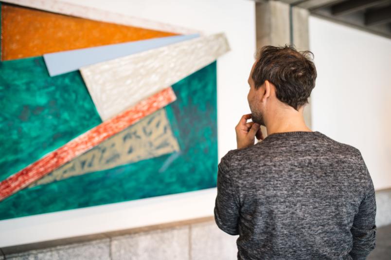 Mann betrachtet ein Kunstwerk.