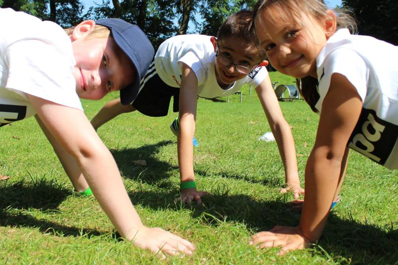 Drei Kinder machen Liegestütze