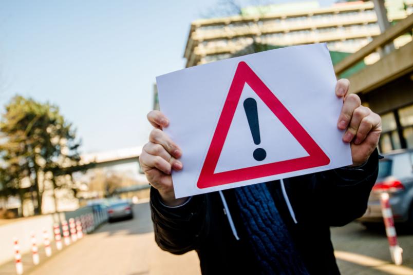 Ein Mann hält ein Warnschild