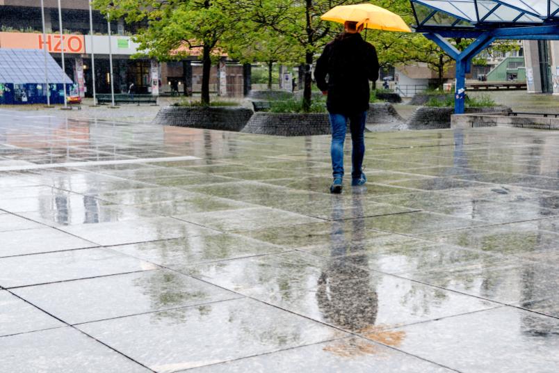 Mann mit gelben Regenschirm