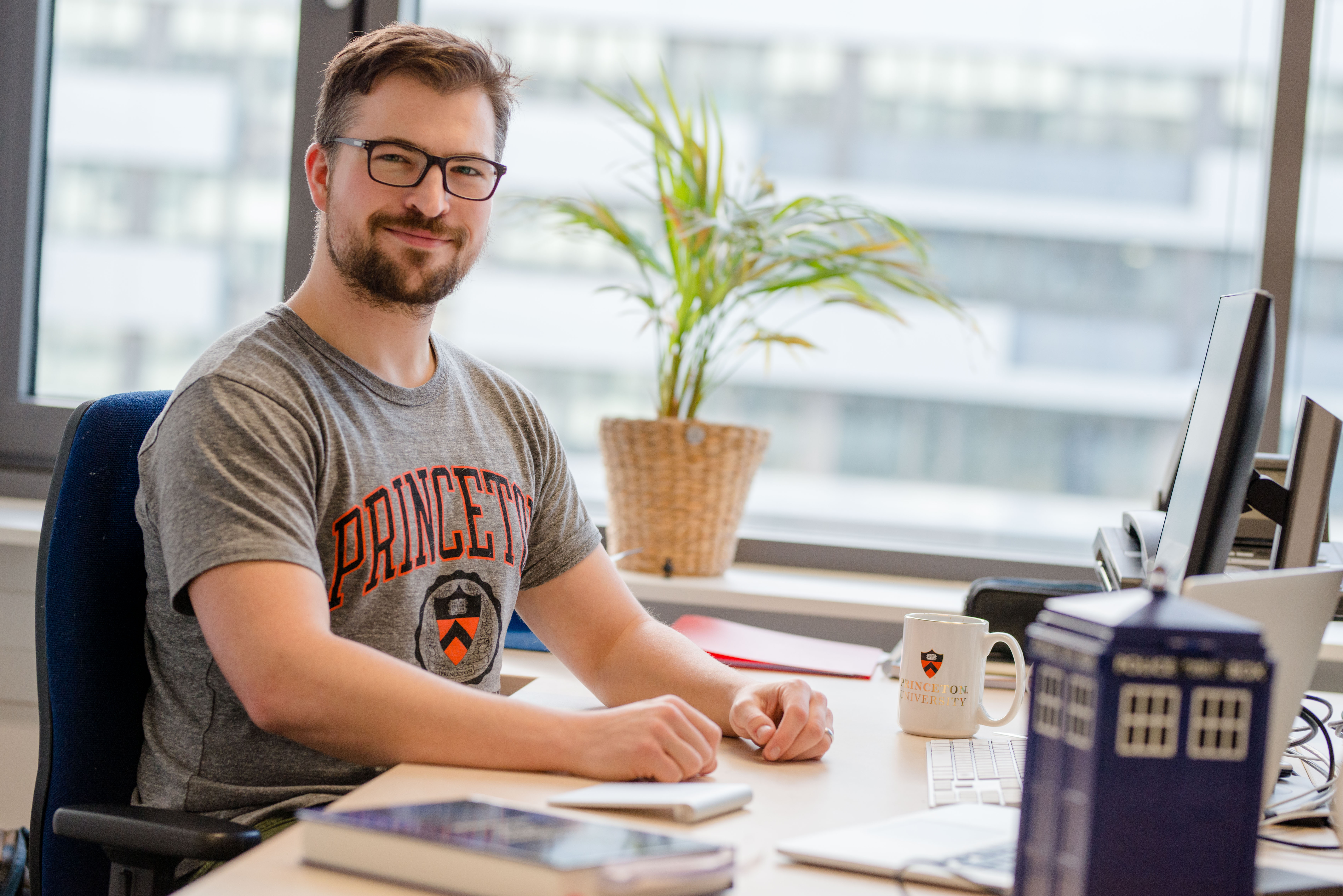 Mann sitzt an einem Schreibtisch. 