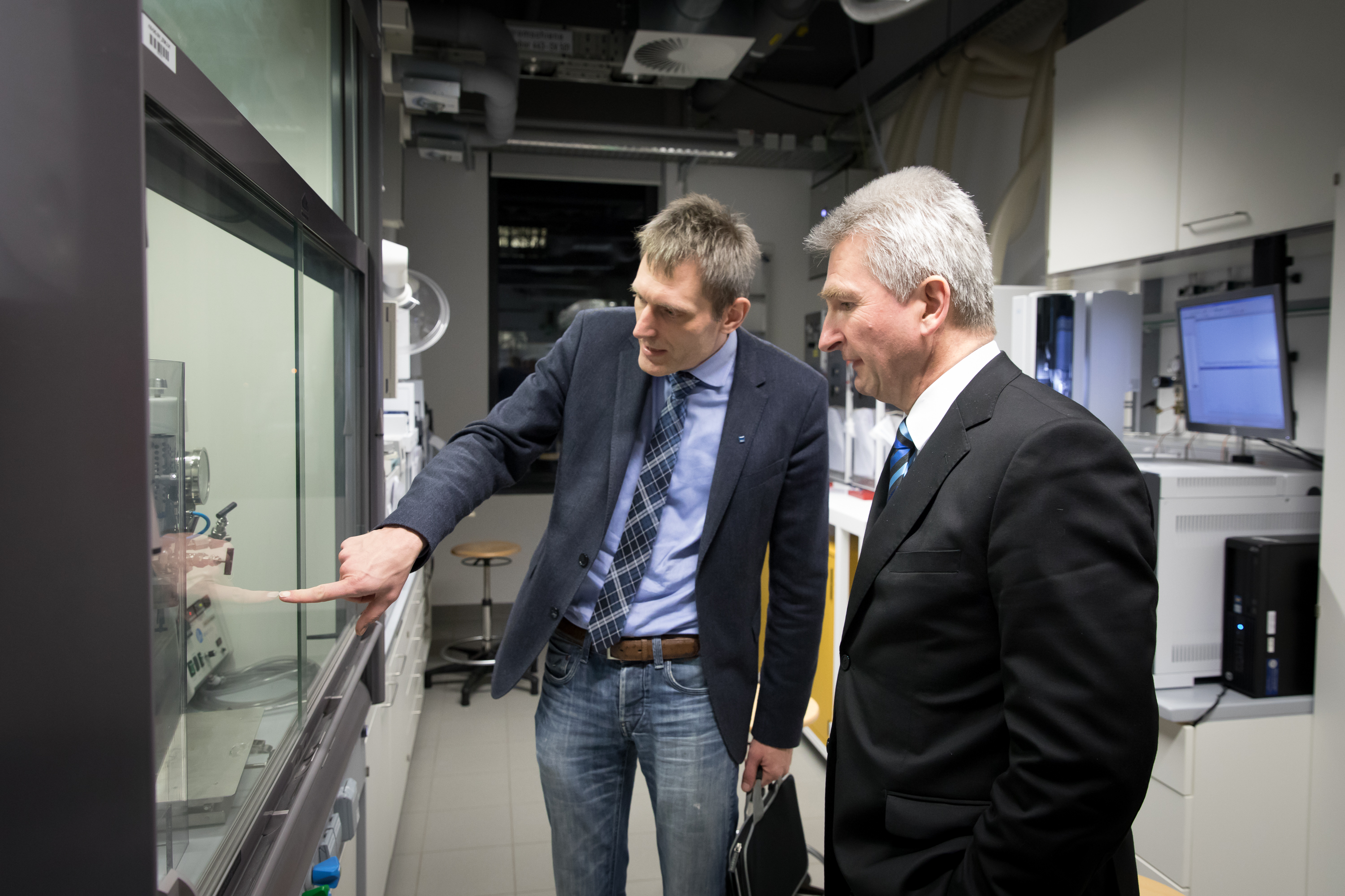 Lukas Gooßen erläutert dem NRW-Wirtschaftsminister Andreas Pinkwart ein chemisches Experiment hinter Glas