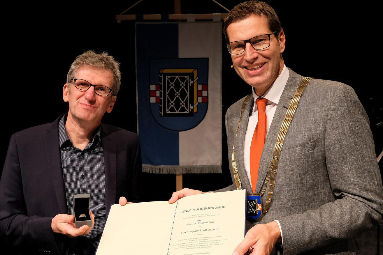 Oberbürgermeister Thomas Eiskirch (rechts) übergibt den Ehrenring an Christof Paar.