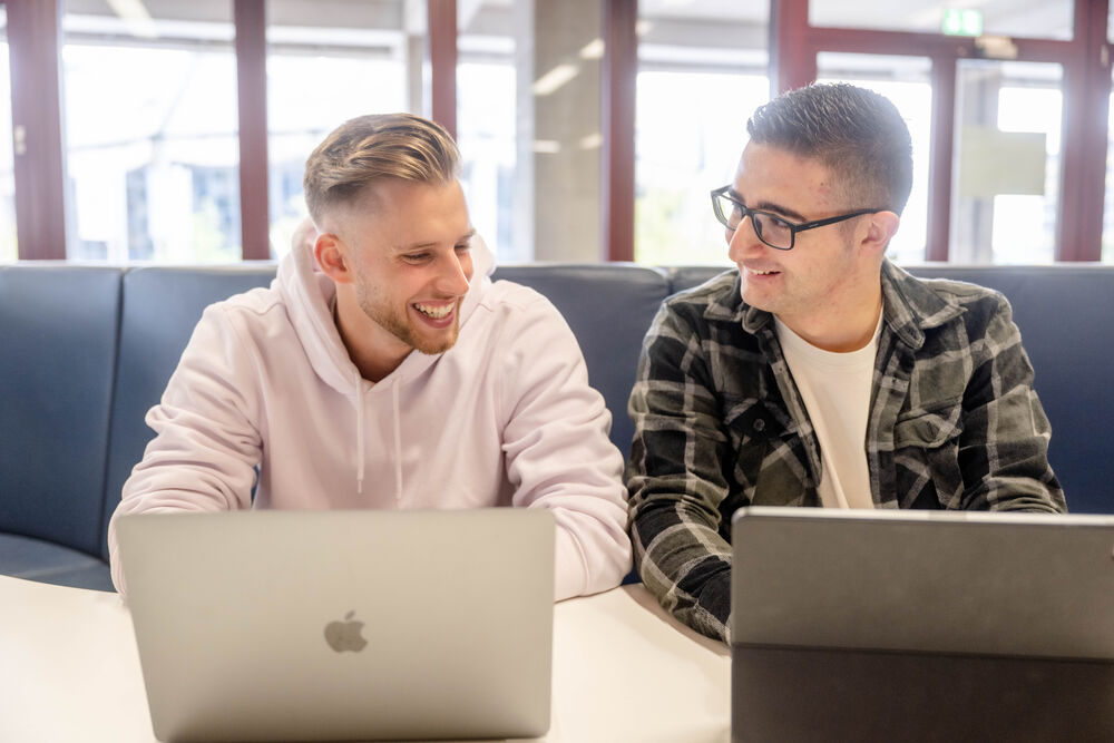 Zwei Studierende lernen an Laptops.