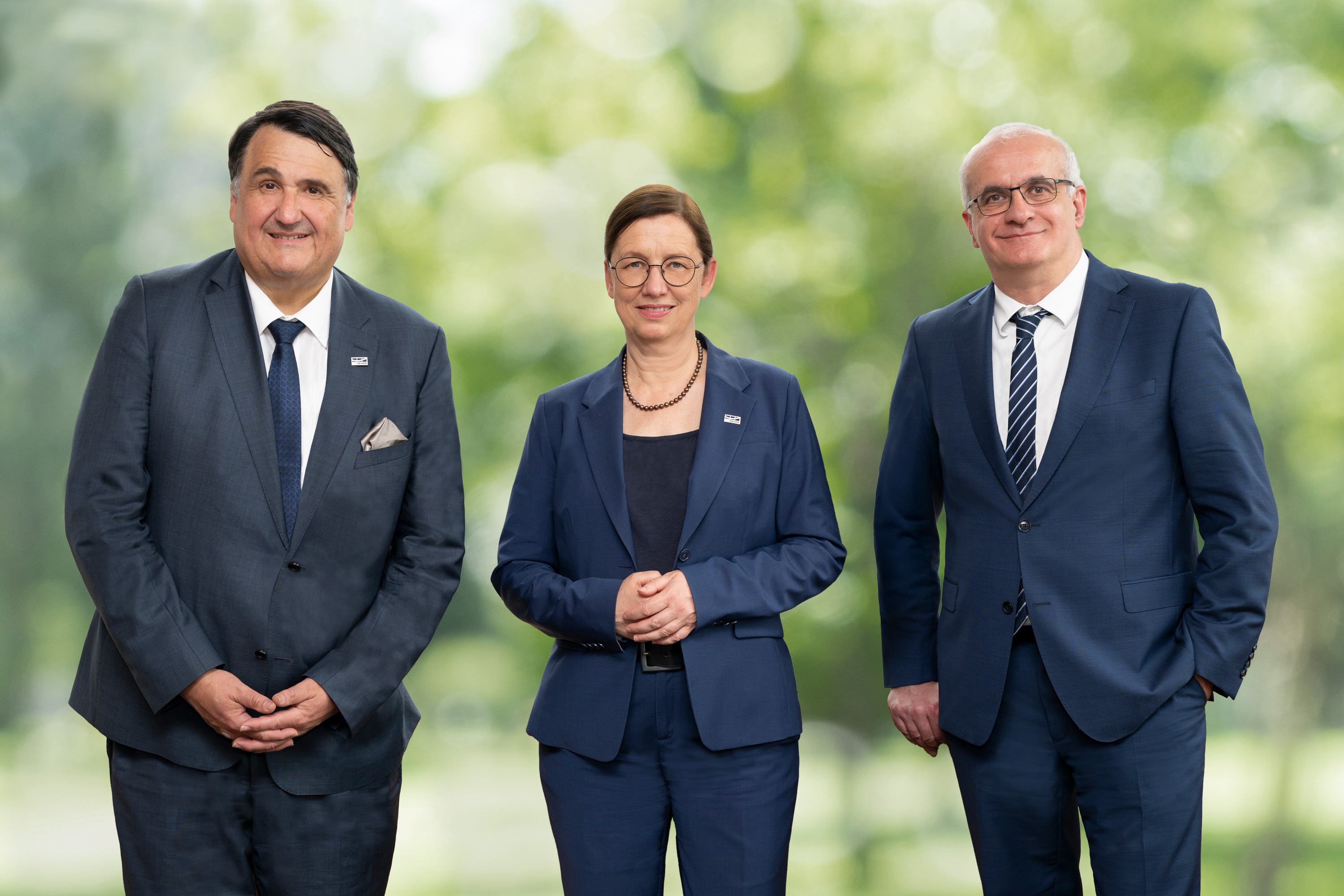 Drei Personen vor grünem Hintergrund