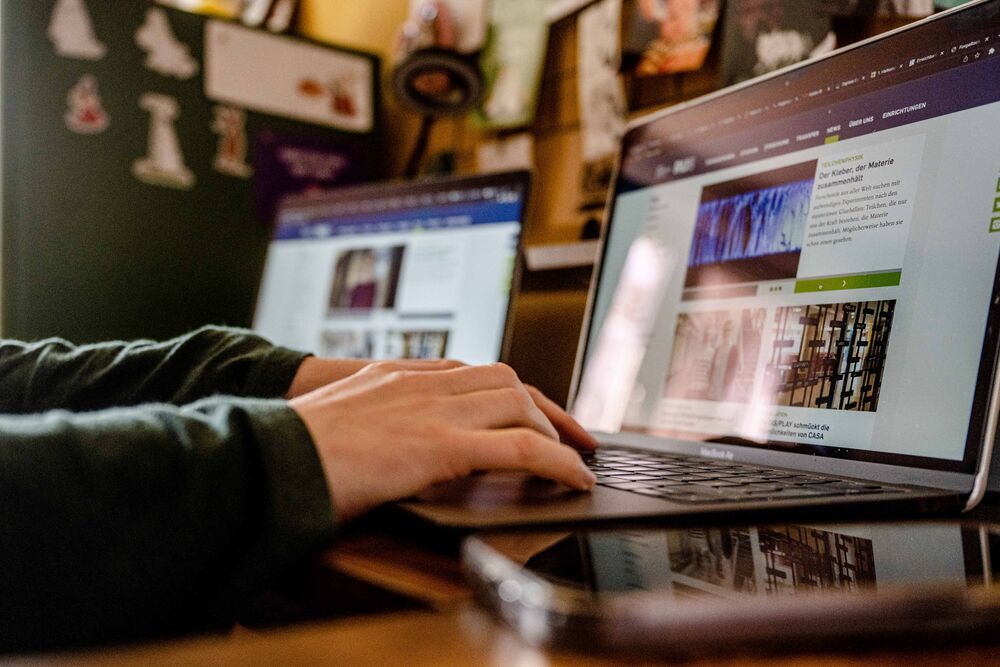 Student sitzt an einem Laptop. Es sind Tastatur und Bildschirm zu sehen. 