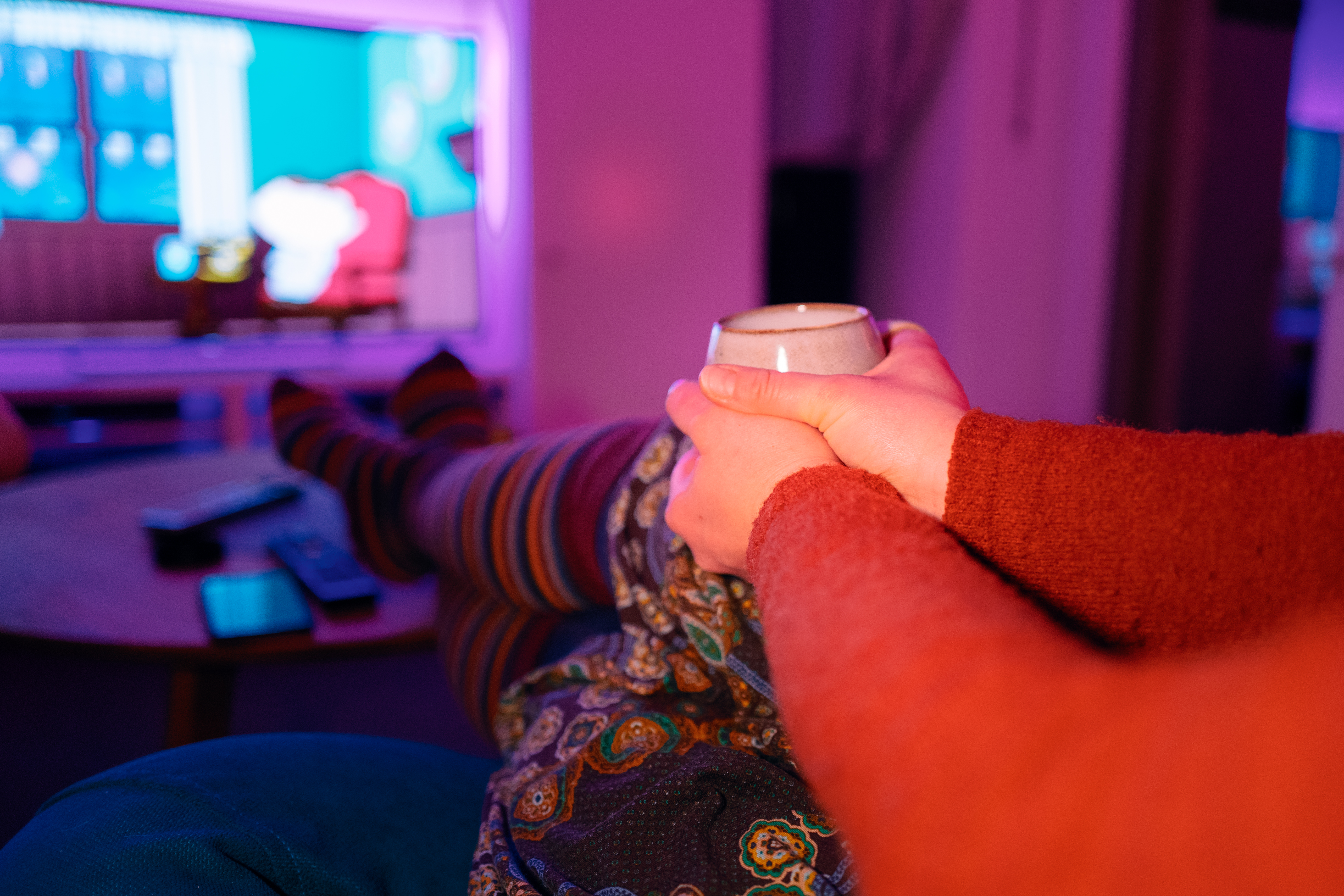 Person mit Teetasse auf Couch