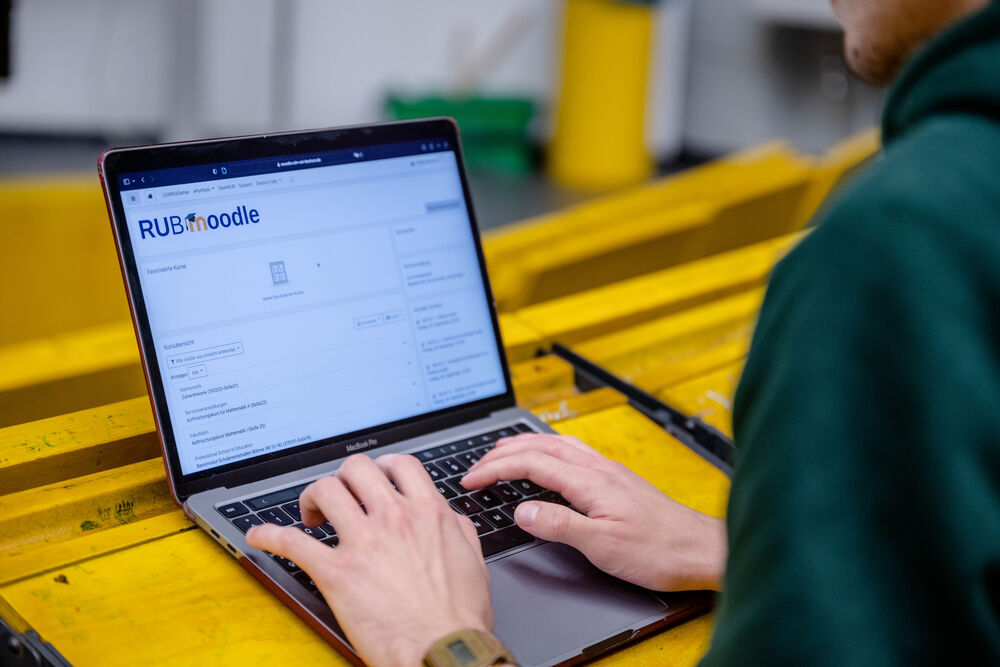 Studentin sitzt im Hörsaa mit Laptop.