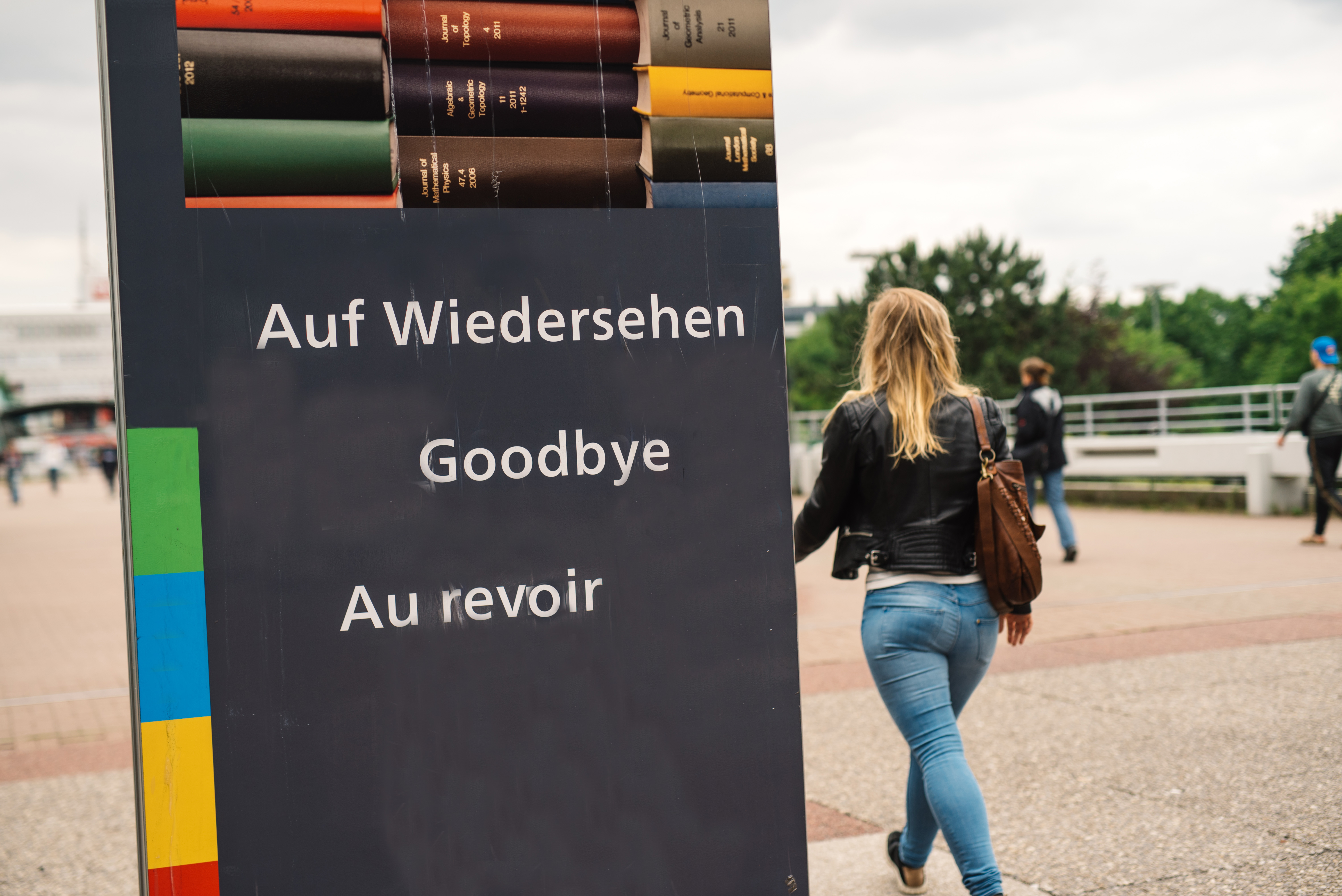 Studentin geht an einem Goodbye-Schild vorbei.