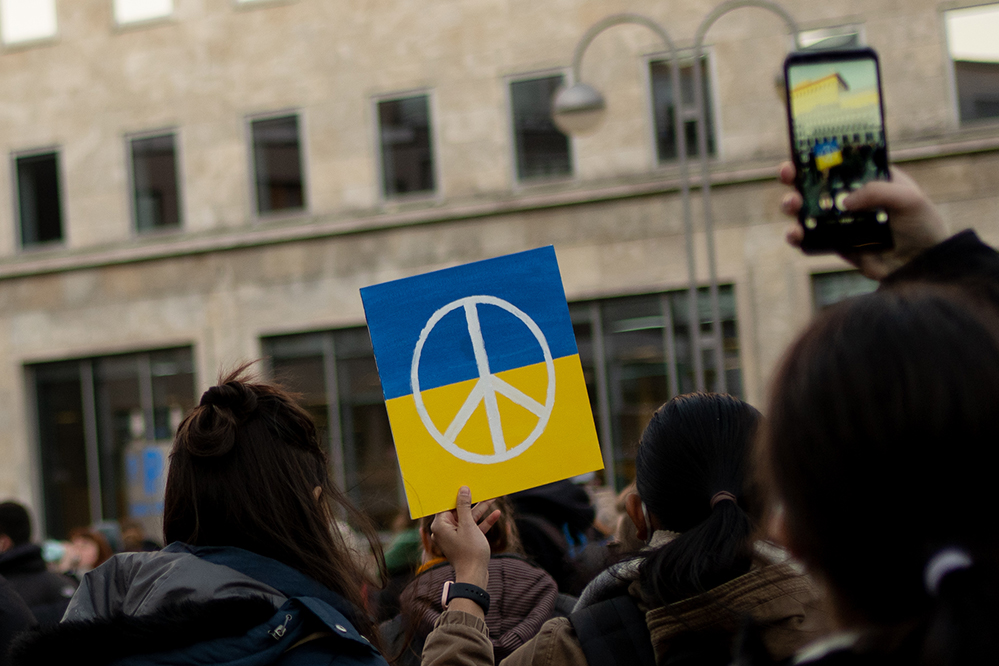 Demonstrierende Personen mit Ukraine-Flagge