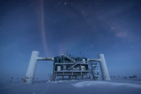 Eine Forschungsstation im Schnee unterm Sternenhimmel in bläulichem Licht