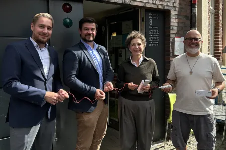 Gruppenbild im Halbschatten: drei Männer, eine Frau