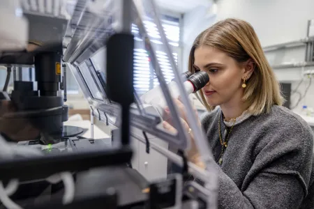 Eine Frau schaut in ein Mikroskop