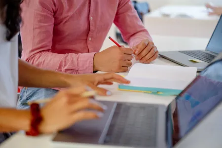 Zwei Personen, die tippen und schreiben