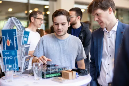 Zwei junge Männer an einem Messestand