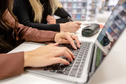 Studentinnen sitzen vor Laptop.
