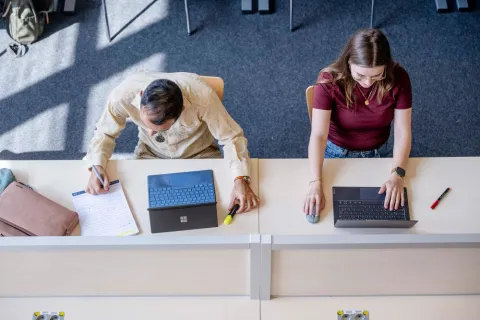 Zwei Studierende lernen am Laptop