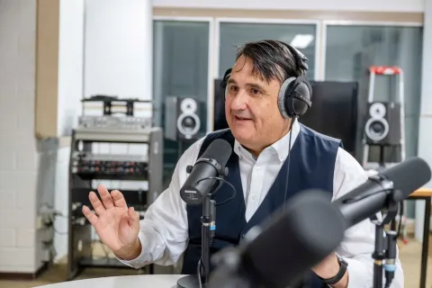 Rektor Martin Paul mit Mikrofon und Kopfhörern in einem Aufnahmestudio.