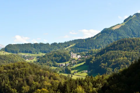 Landschaft mit Bergen, Wald und einem Dorf mit Kirche
