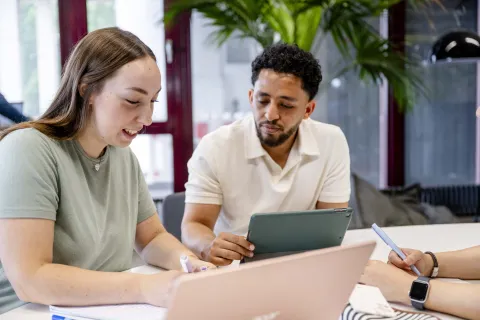 zwei Studis schauen auf Laptop