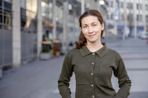 Porträt von junger Frau mit dunkelbraunen Haaren und in dunkelgrüner Bluse.