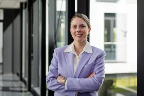 Eine Frau in fliederfarbenem Blazer