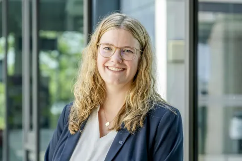 Eine blonde Frau im grauen Jackett