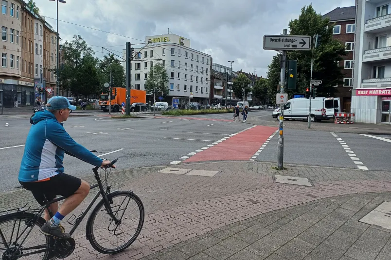 Radfahrer fährt auf eine rote Radfuhrt zu