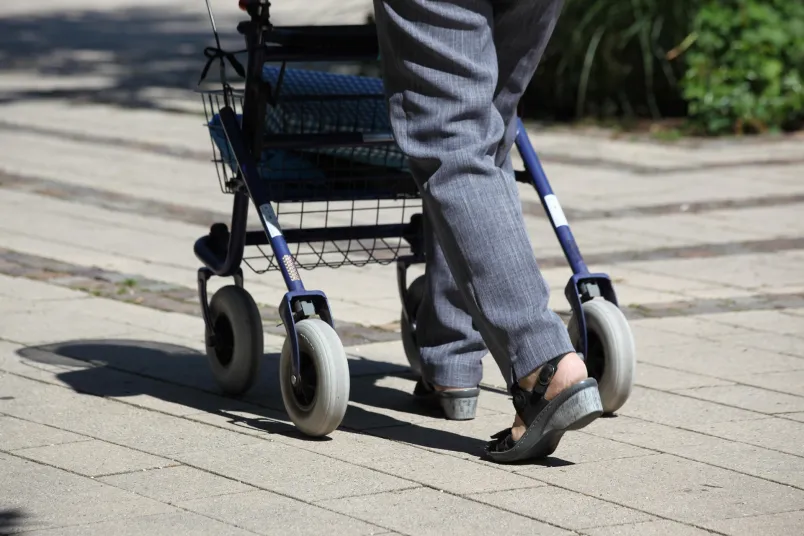 Person, die einen Rollator schiebt