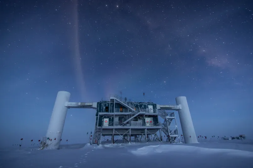 Eine Forschungsstation im Schnee unterm Sternenhimmel in bläulichem Licht