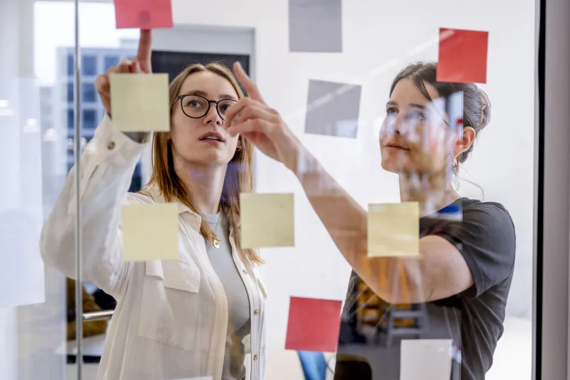 Zwei Frauen hinter Plexiglas
