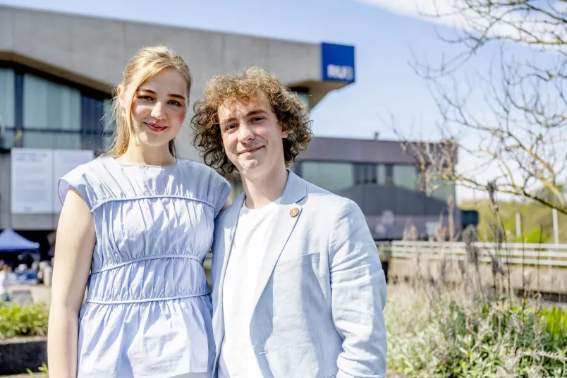 Studentin und Student vor frühlingshafter Kulisse