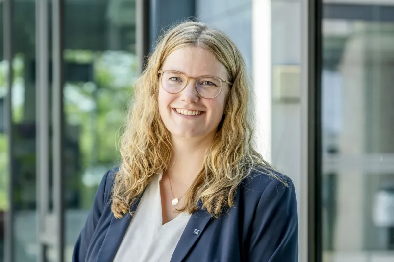 Eine blonde Frau im grauen Jackett