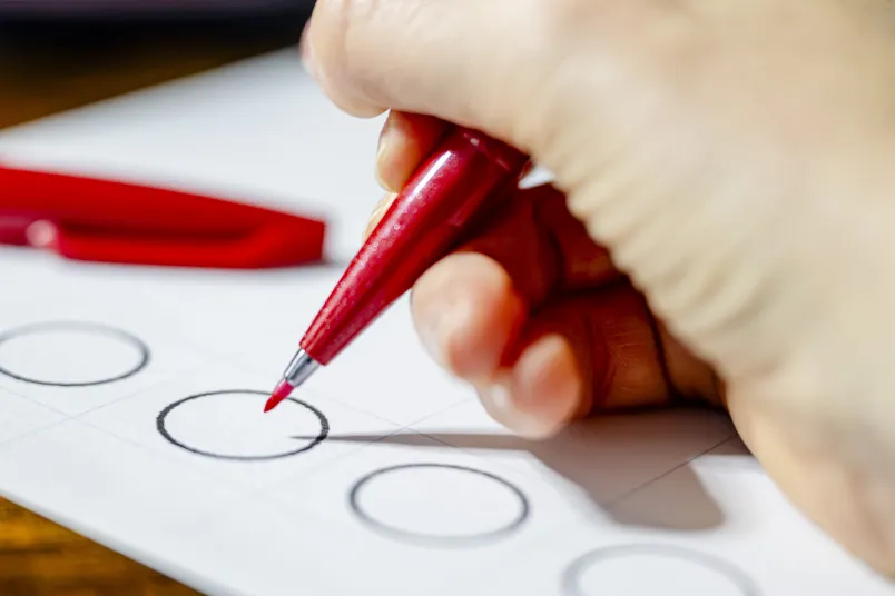 Symbolbild mit einem Wahlzettel und einem Stift