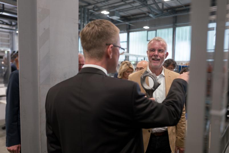 Zwei Männer in Anzügen in einer Fabrikhalle