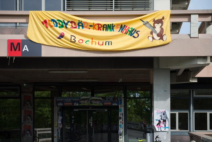 Ein Banner hängt an einem Gebäude. Es steht Teddybärkrankenhaus drauf.