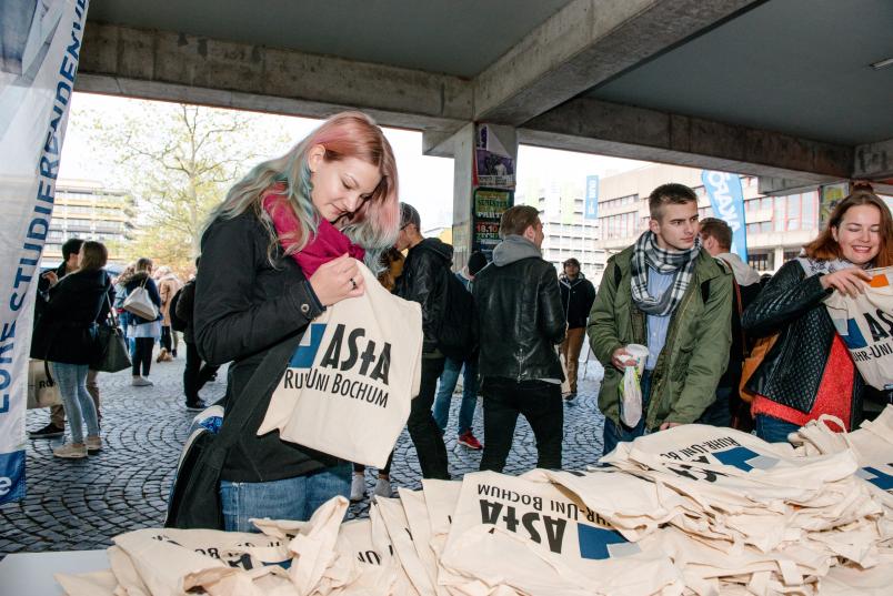 Eine neue Studentin erhält einen Beutet mit Informationen für Erstsemester.