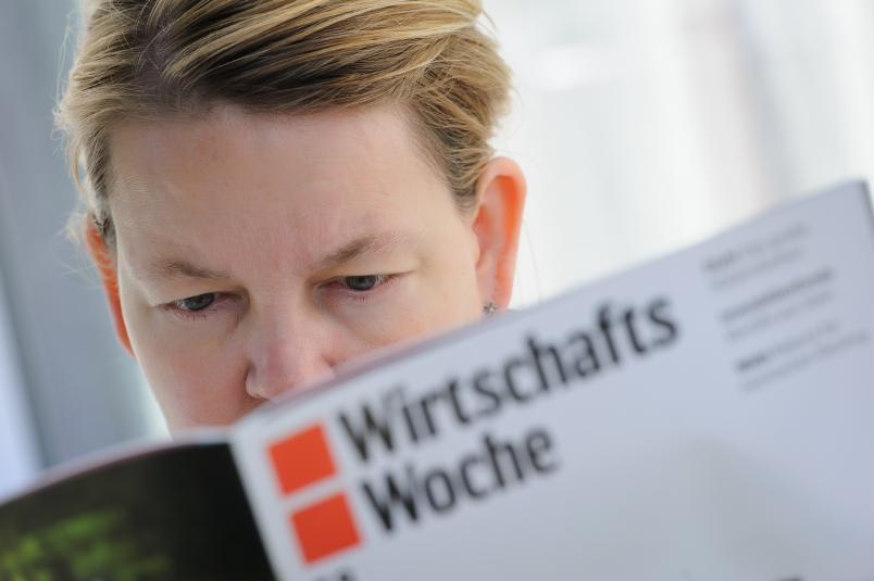 Eine Frau liest die Wirtschaftswoche.