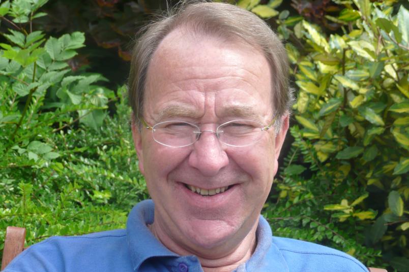 Porträt eines etwa 60-jährigen Mannes vor grünem Hintergrund