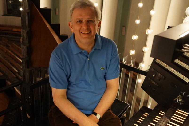 Porträt eines etwa 60-jährigen Mannes, der an einer Orgel sitzt