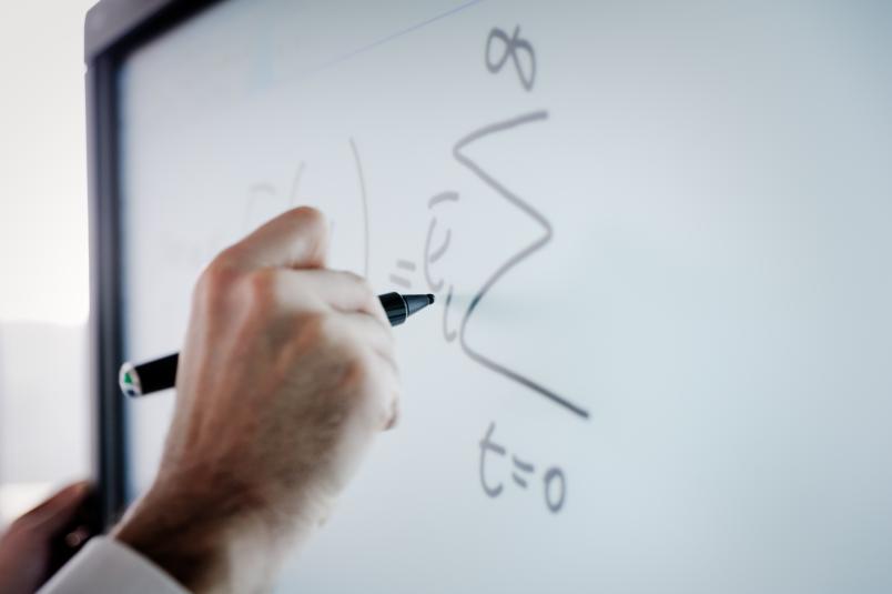 Formeln werden an ein Smartboard geschrieben.