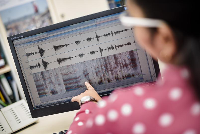 Wissenschaftlerin bei der Audioanalyse eines Textes am Rechner