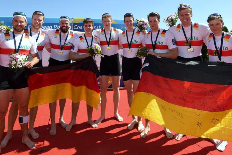 Acht Athleten halten zwei Deutschlandflaggen