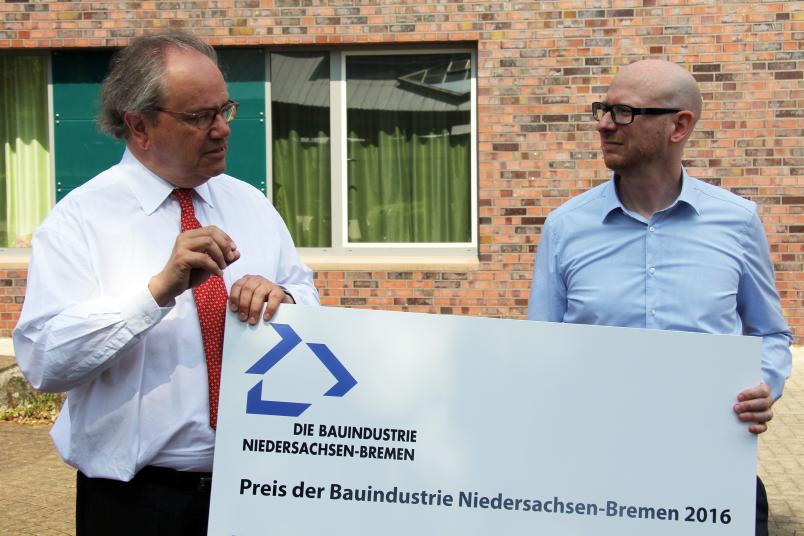 Zwei Männer mit großem Spendenscheck