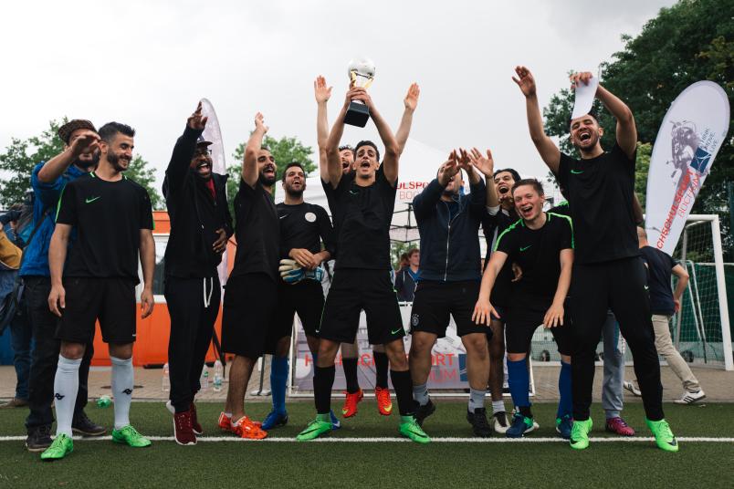 Jubelnde Fußballmannschaft mit Pokal
