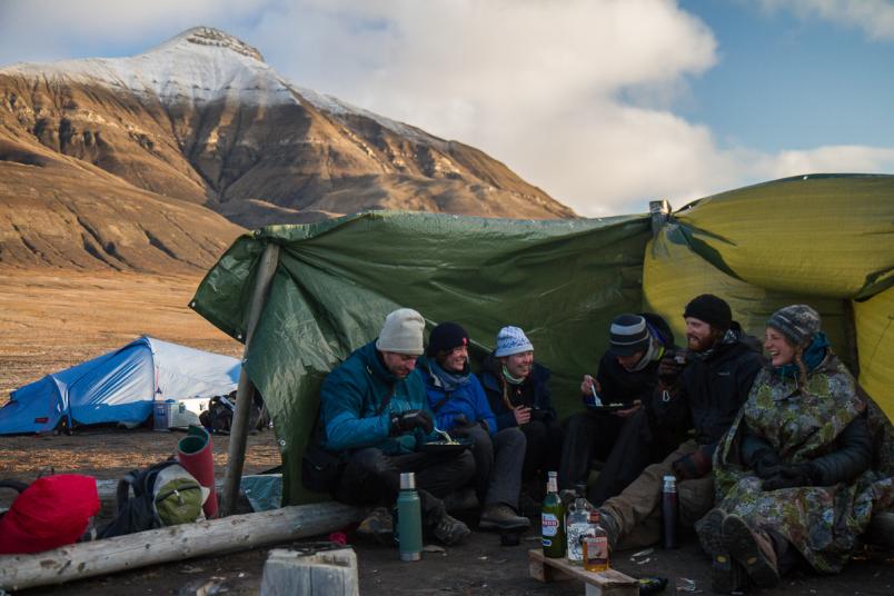 Junge Menschen in warmen Kleidern vor Zelt