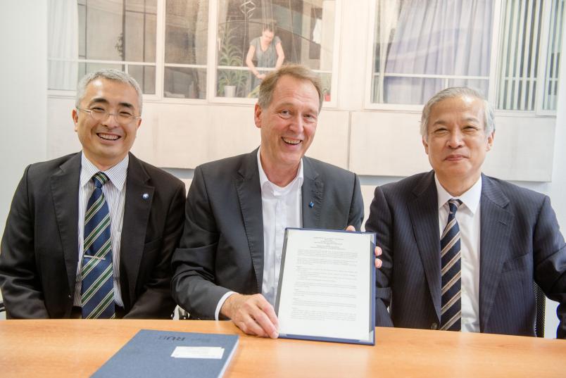 Die Gäste aus Osaka, Prof. Dr. Genji Kurisu (links) und Prof. Dr. Haruki Nakamuri (rechts), bei der Vertragsunterzeichnung mit RUB-Rektor Prof. Dr. Axel Schölmerich