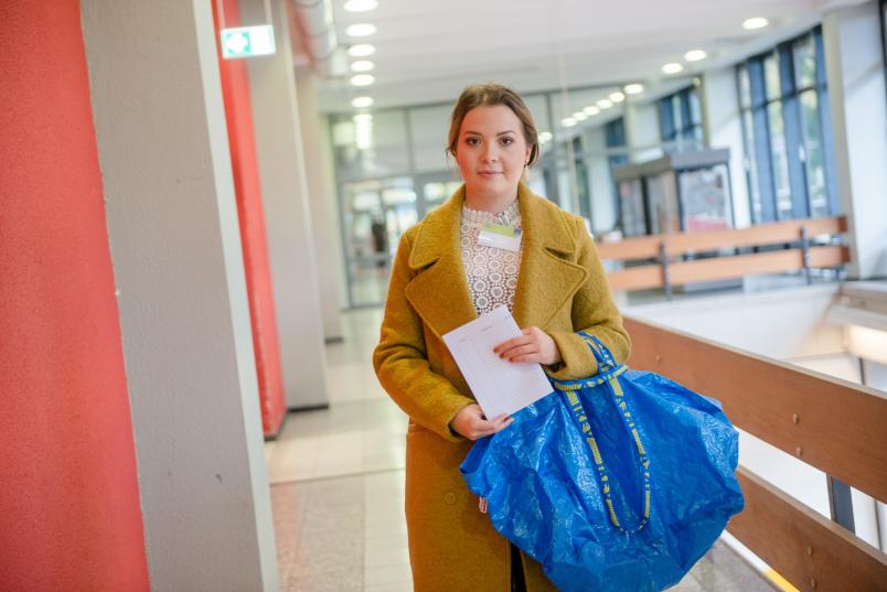 Junge Frau mit einer Tasche in der Hand.