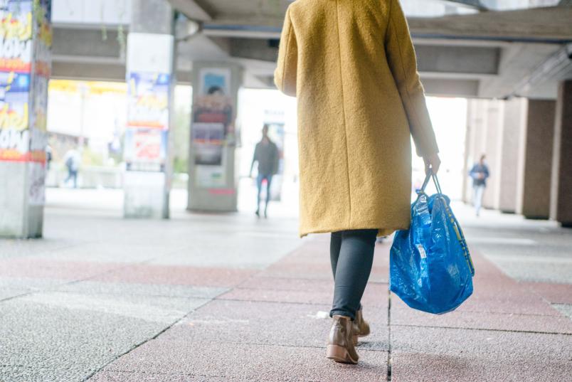 Frau von hinten, die eine Tasche trägt.